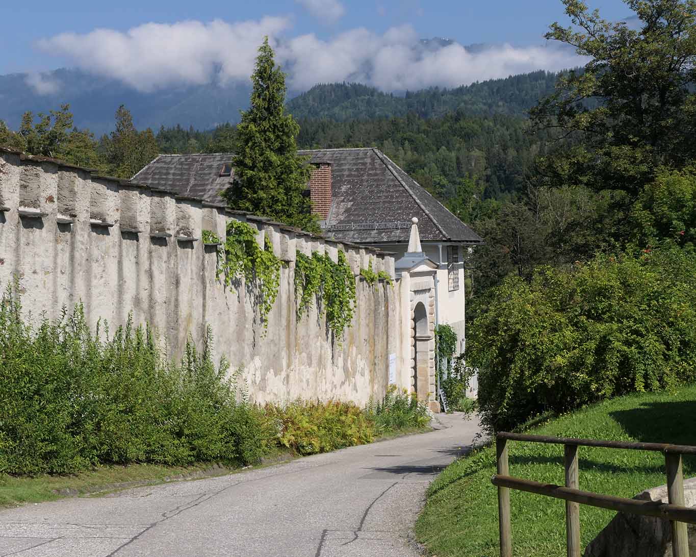 Klostertor von Wernberg seitlich mit Wolken über den Kärntner Bergen.
